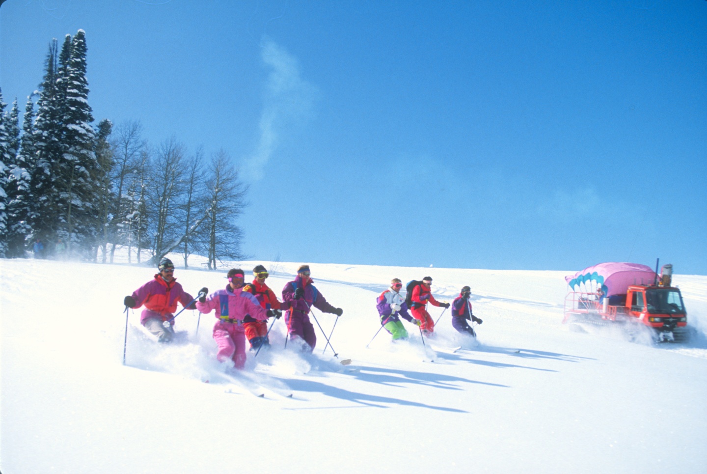 A group of people cat skiing in the 80s