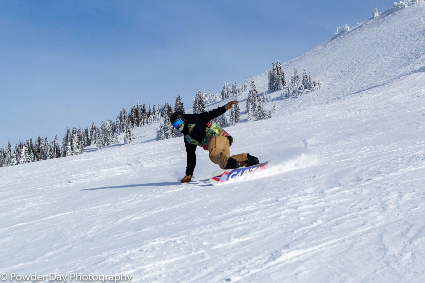A snowboarder riding down a mountain