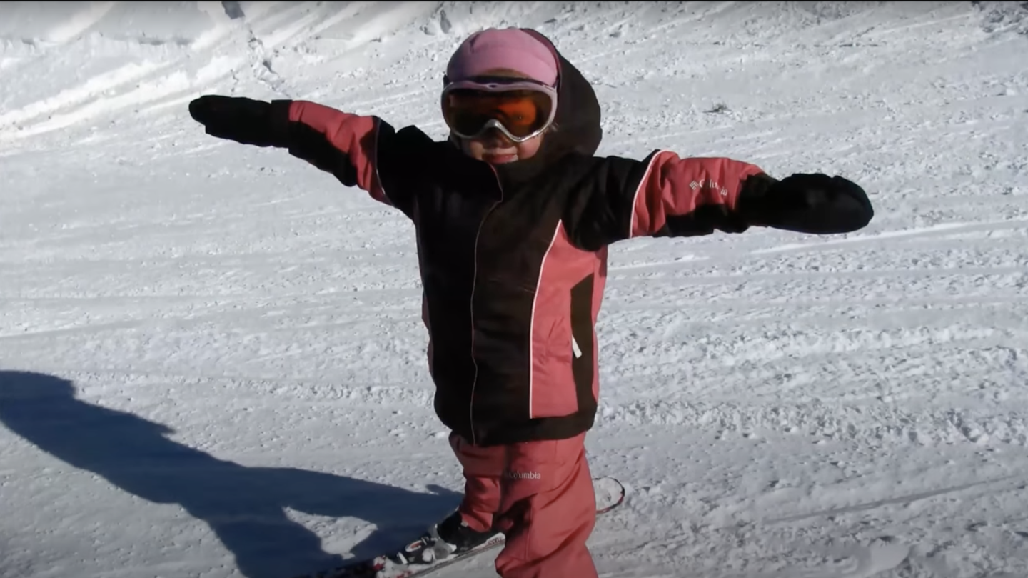 Child on ski's holding out arms