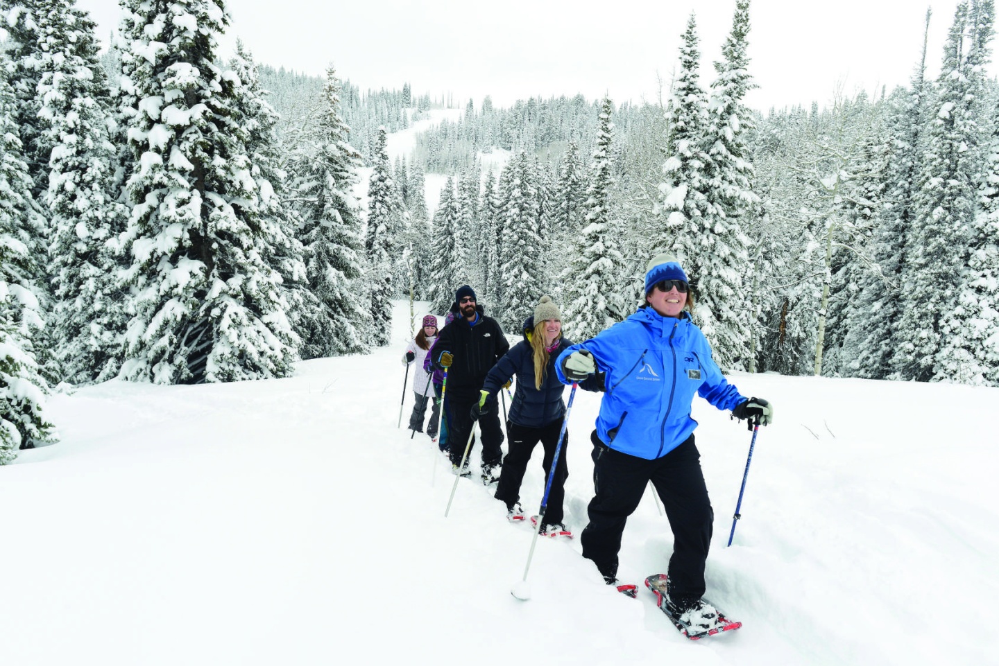 A group of adults go snowshoeing