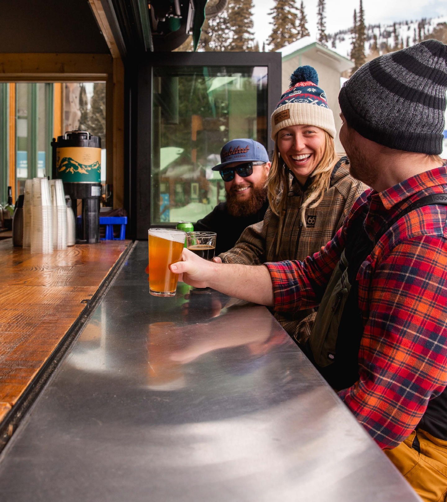 Three adults enjoying a beer at a bar