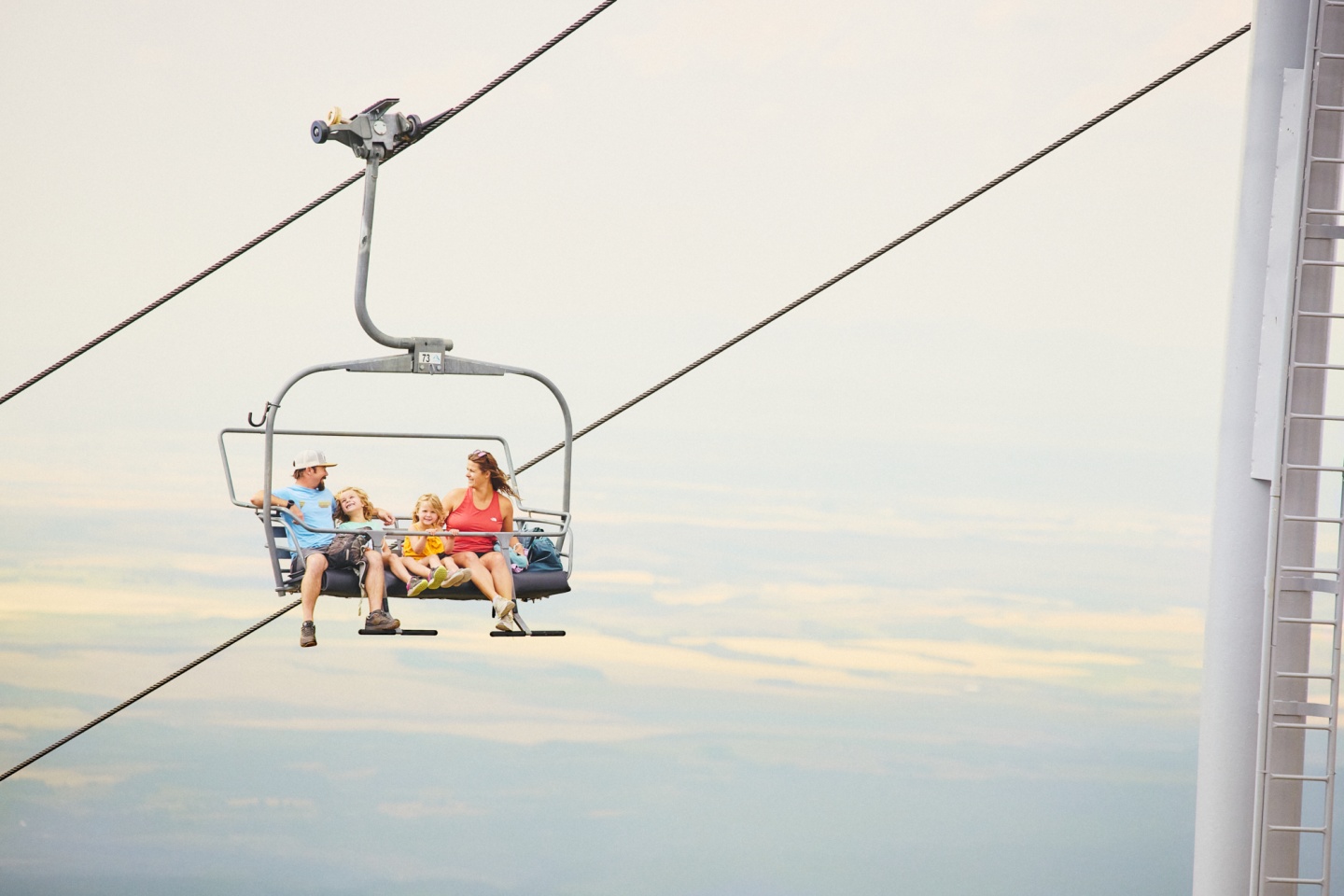 A family of four enjoying a scenic chairlift ride