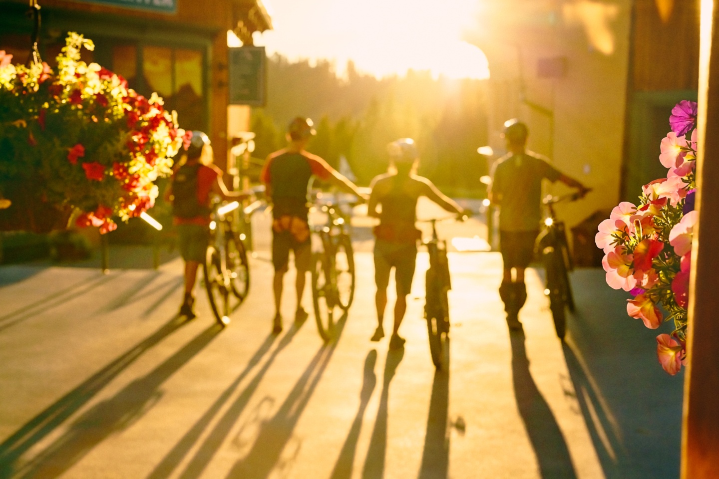 A group of four walking their bikes through a resort
