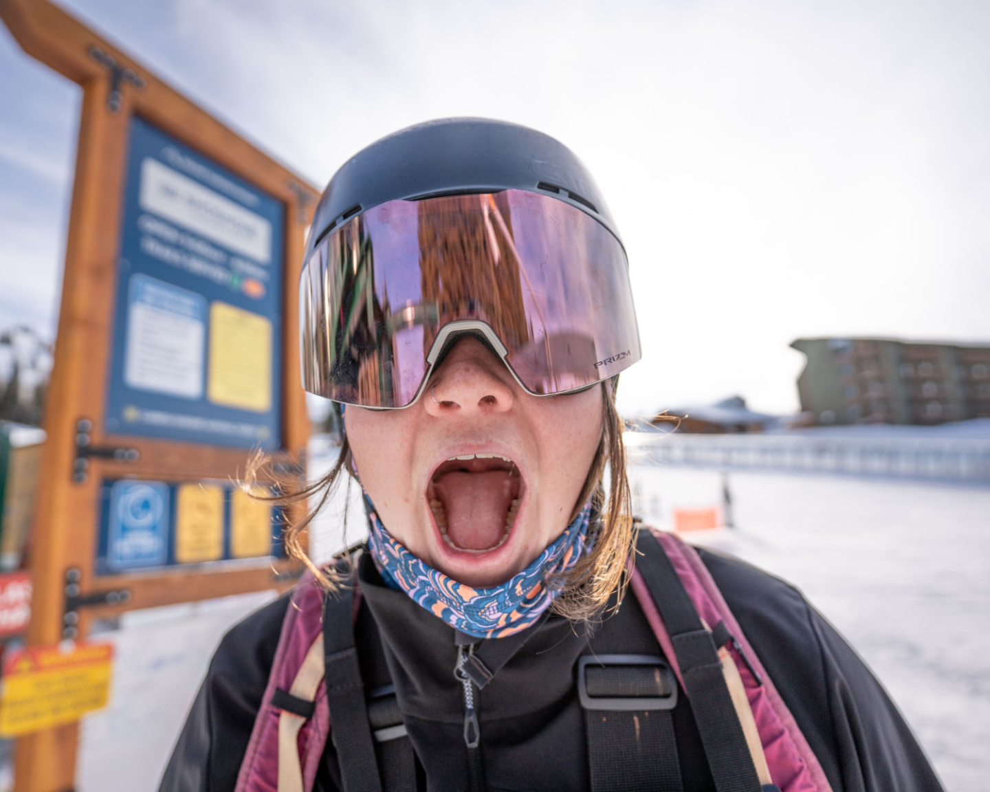 Person in ski gear exclaims excitedly on snowy slope.
