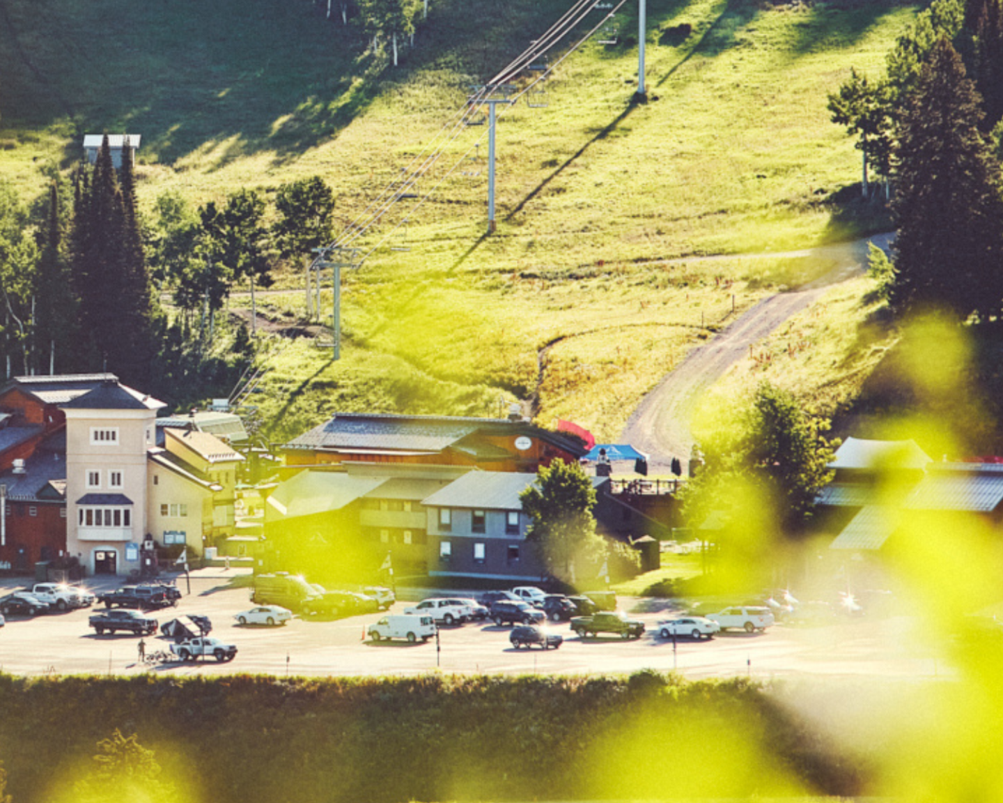 Small village nestled in a sunny, green hillside setting.