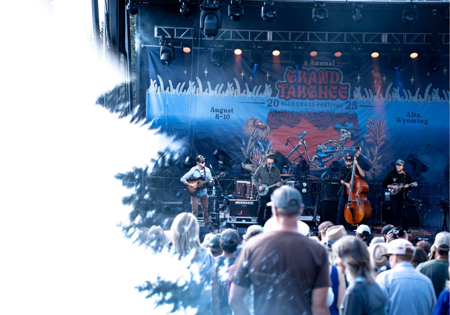 Outdoor concert stage with band performing, audience in foreground.