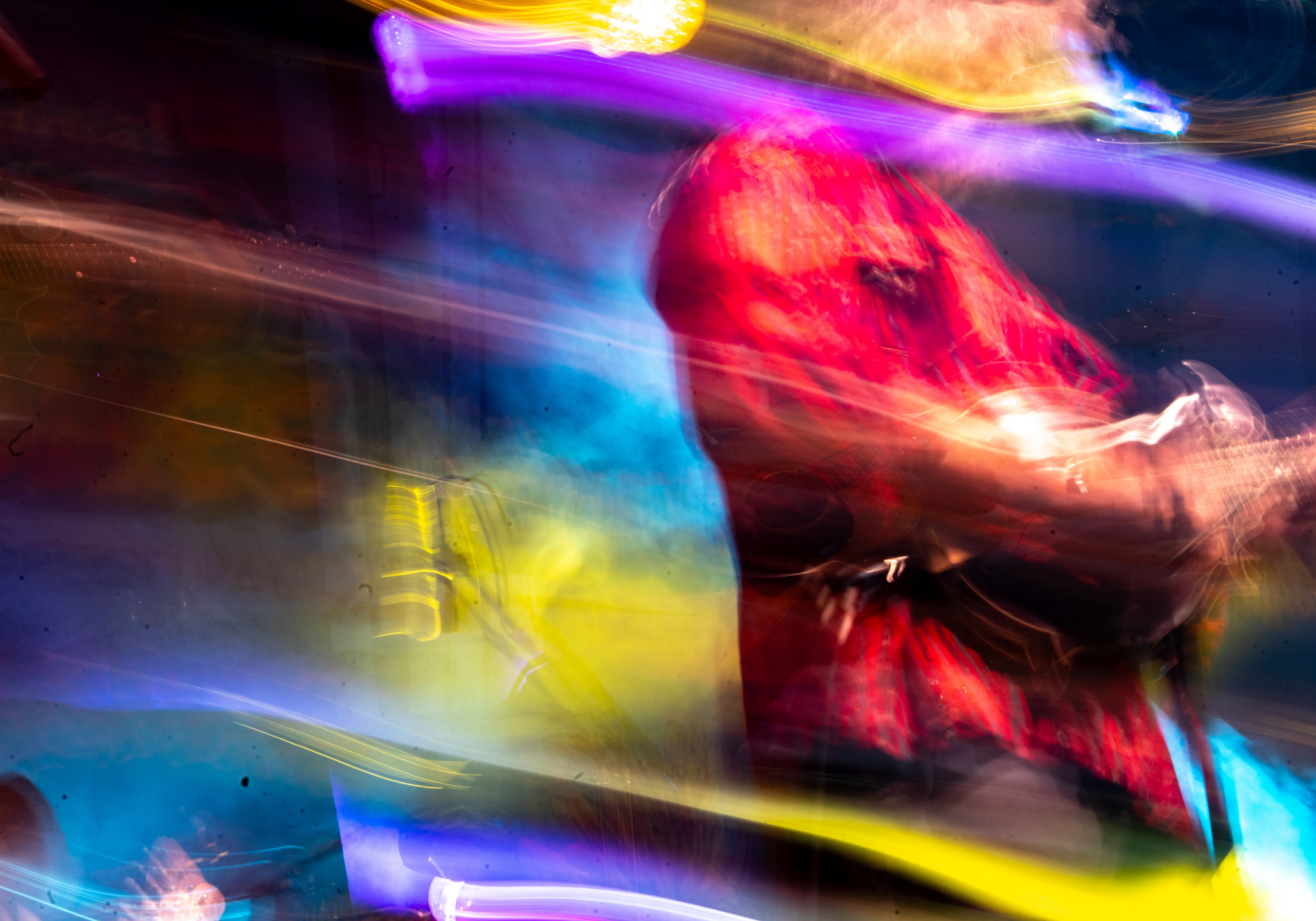 Blurred figure in vibrant colors and streaks of light.