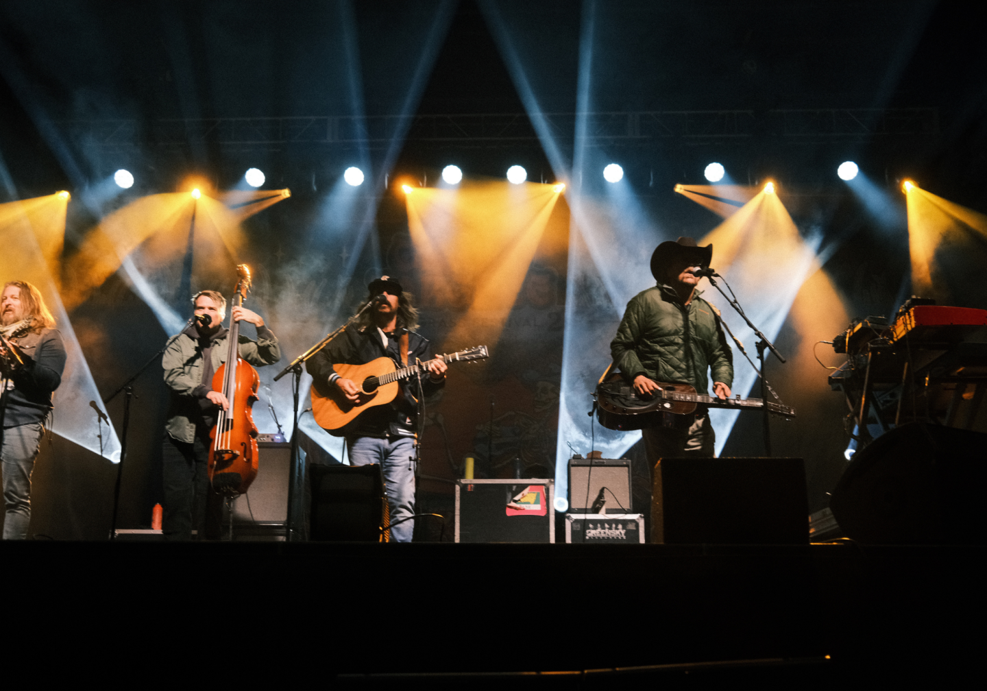 Band performing on stage with colorful lights and instruments.