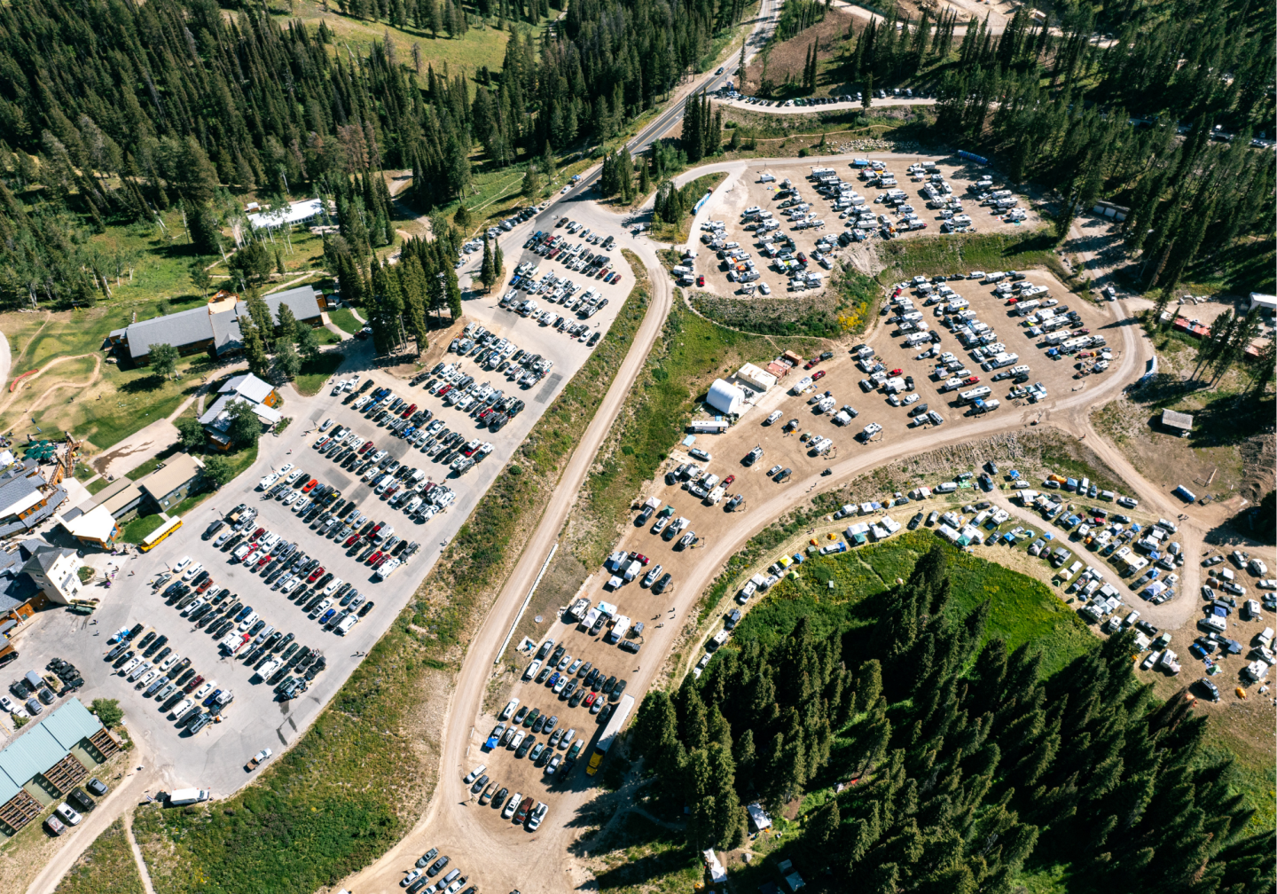 Aerial view of large parking lots surrounded by trees.