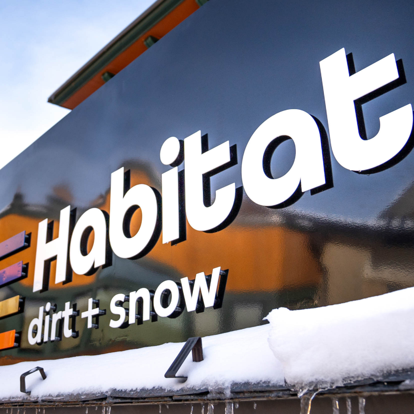 Habitat logo on a snowy sign.