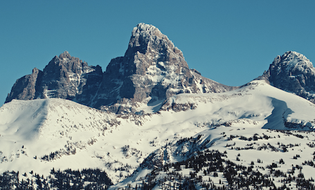 Snow-covered mountain peaks under a clear blue sky.