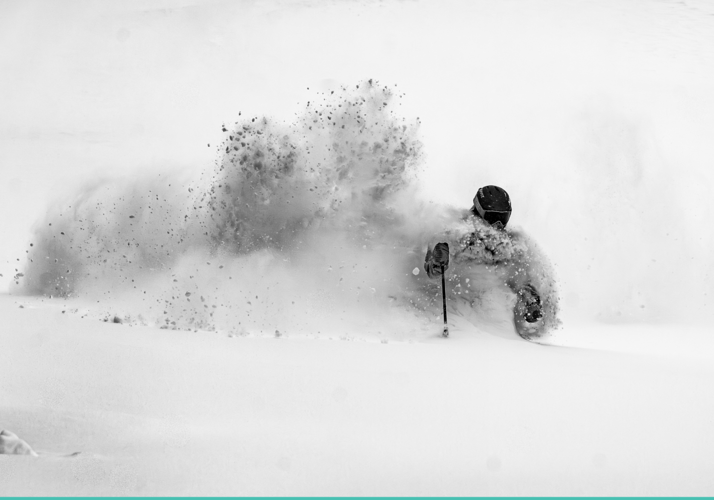 Skier moving through deep snow in a grayscale scene.