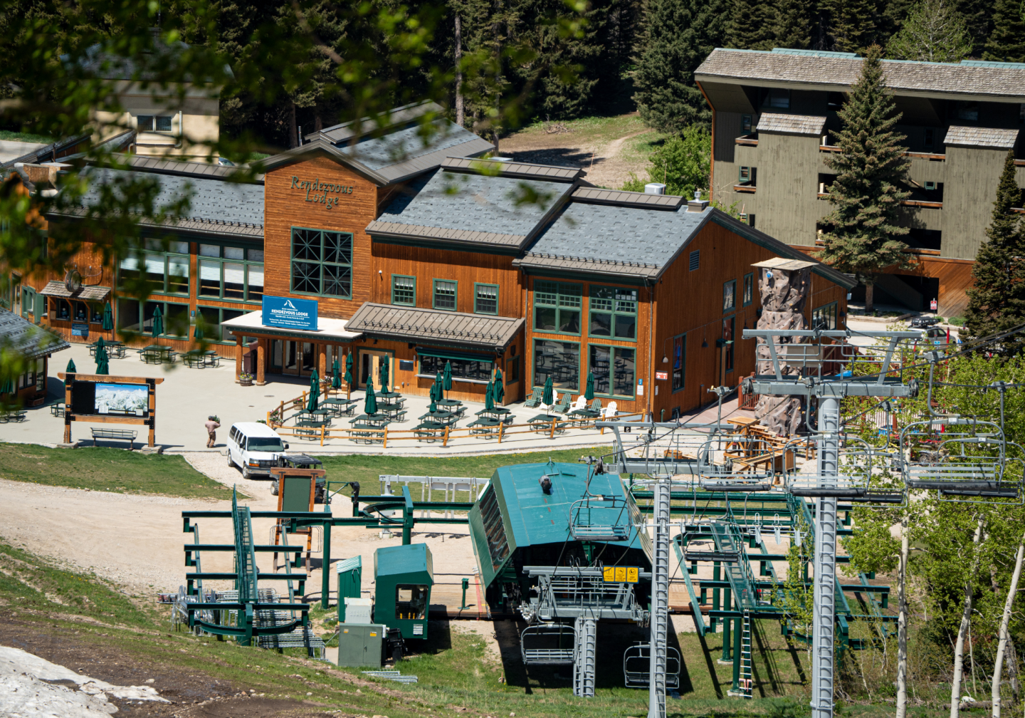 Ski lodge with a chairlift in a wooded area on a sunny day.