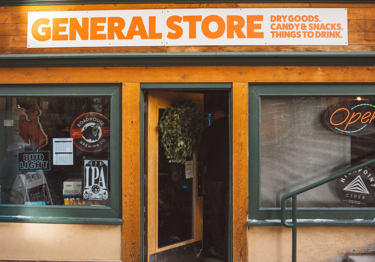General store with wooden exterior and neon "Open" sign.
