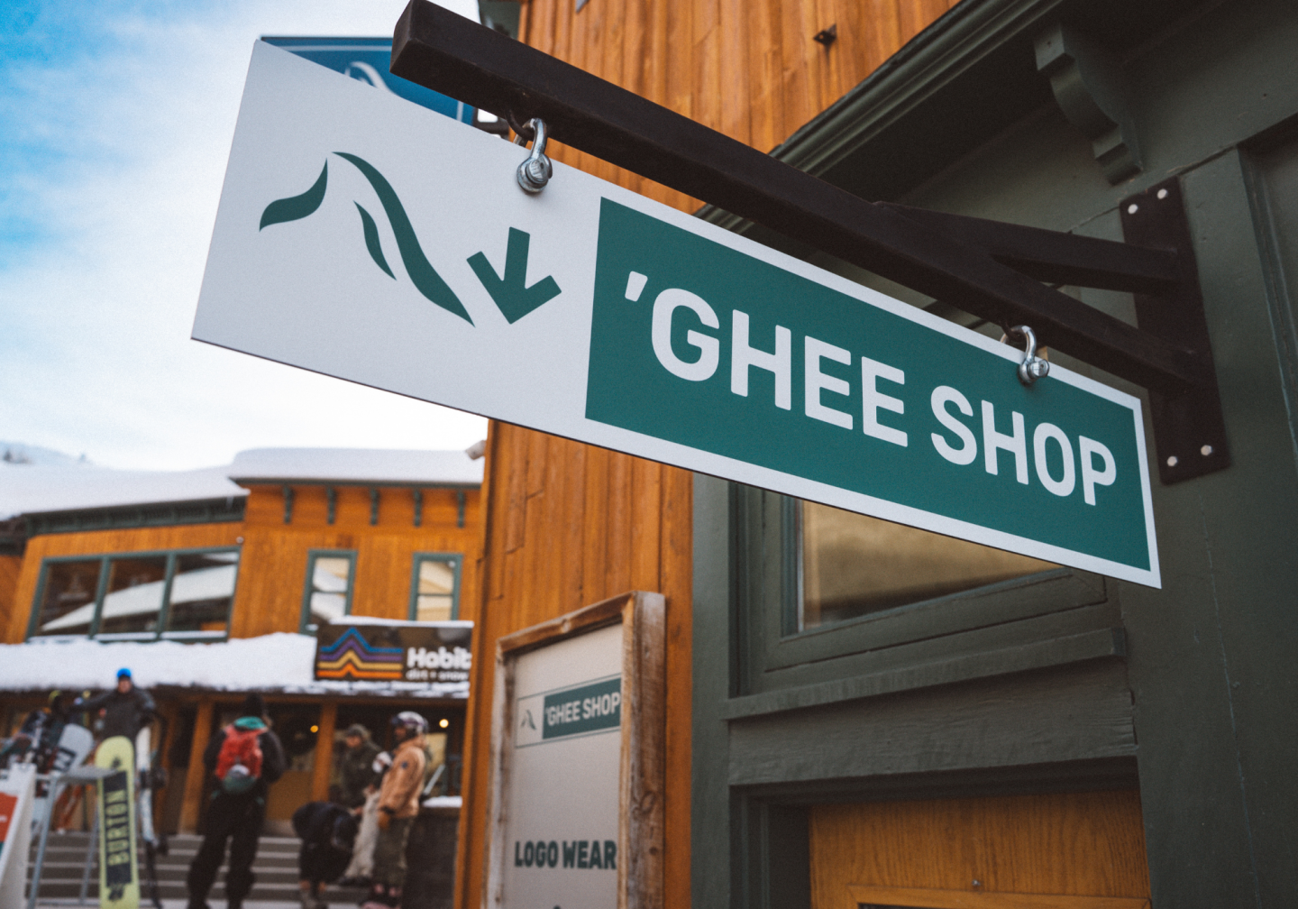Ghee Shop sign with snowy mountain icon, outdoor shopping area in background.