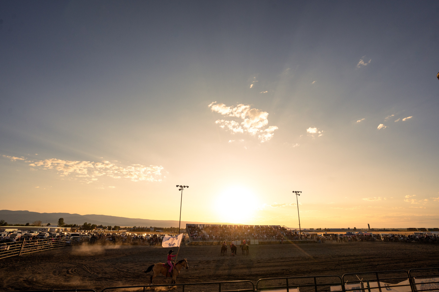 Sunset over a crowded stadium with a clear sky.