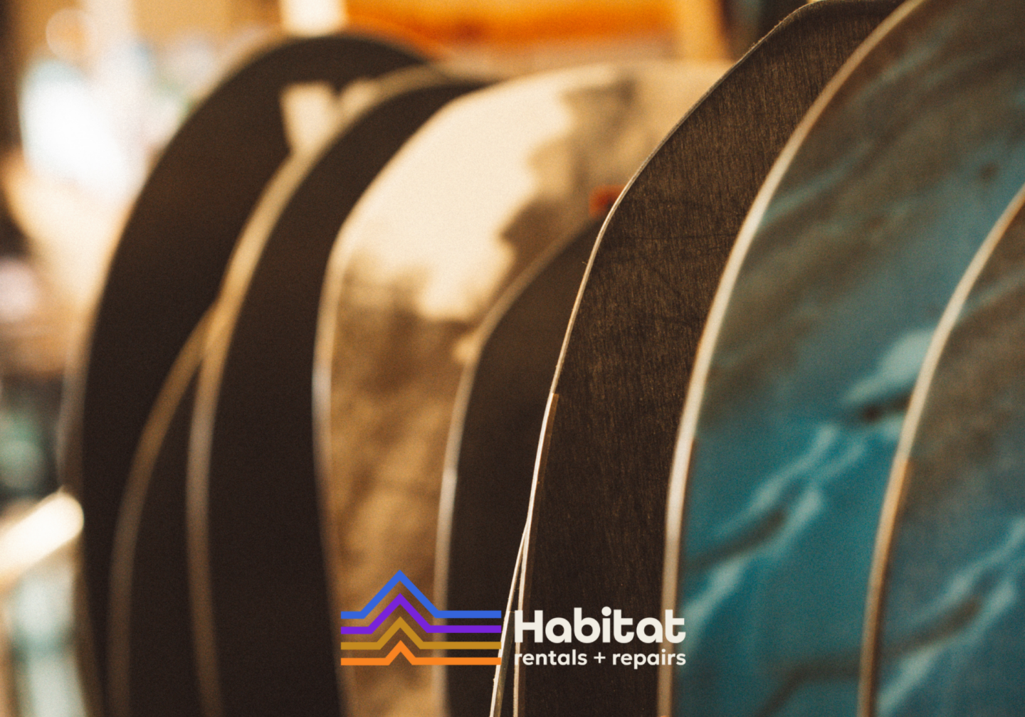 Row of patterned fabric rolls, with a Habitat logo at the bottom center.